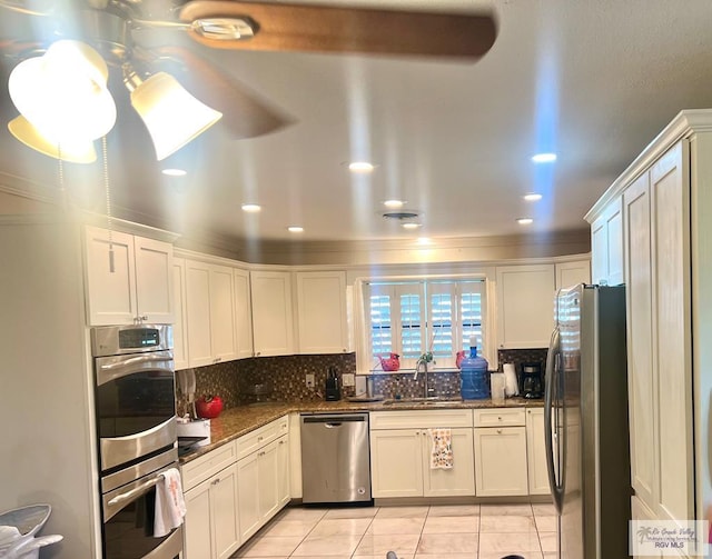 501 W Palm Valley Dr, Harlingen, TX 78552 - kitchen with white cabinets, stainless steel appliances, a sink, tasteful backsplash, and light tile patterned floors
