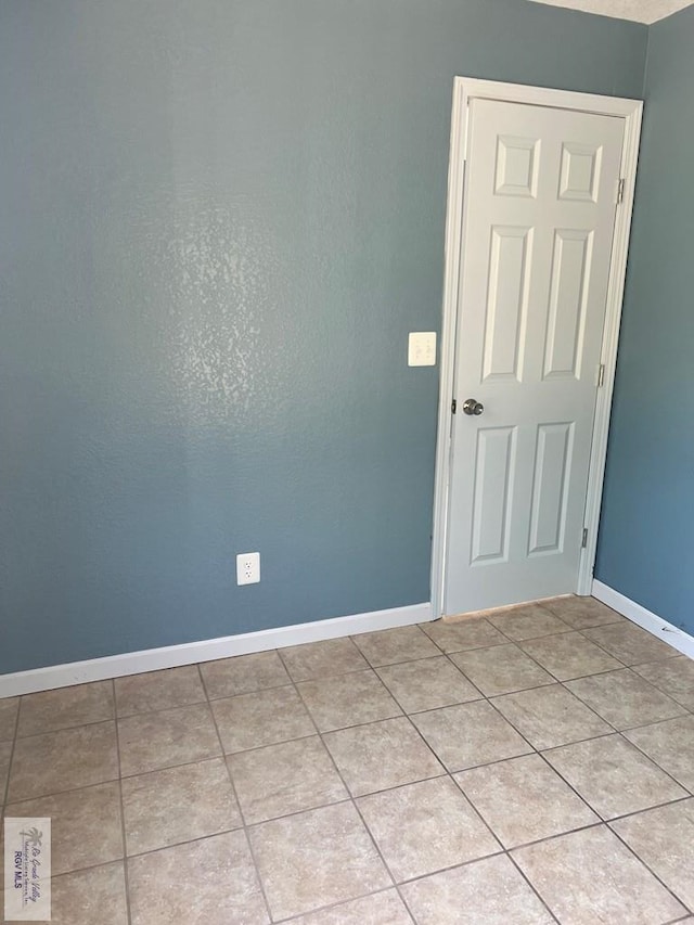 unfurnished room featuring light tile patterned floors and baseboards