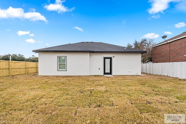 rear view of property with a lawn