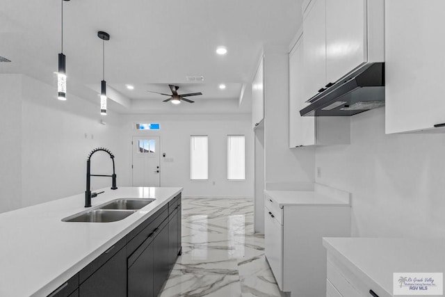 kitchen featuring white cabinetry, ceiling fan, decorative light fixtures, and sink