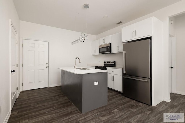 kitchen with sink, dark wood-type flooring, an island with sink, white cabinets, and appliances with stainless steel finishes