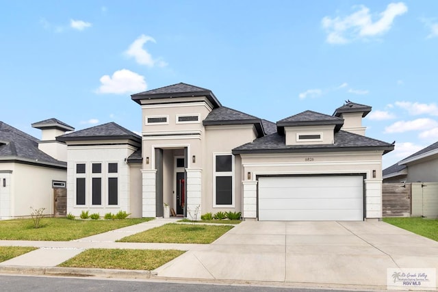 prairie-style house featuring a garage and a front yard