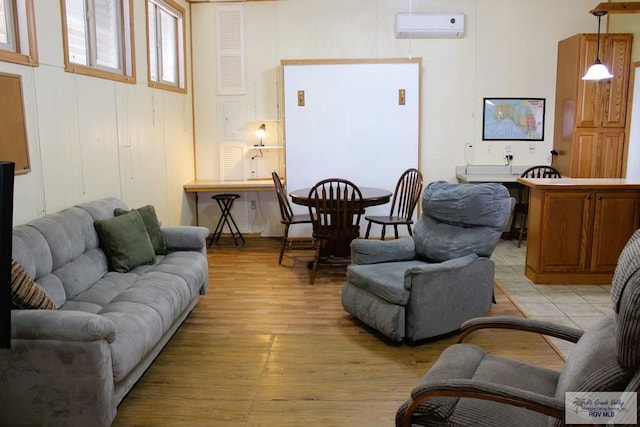 living room featuring light wood-type flooring and an AC wall unit