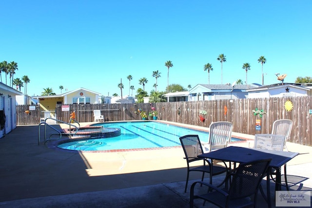 view of pool featuring a patio area and an in ground hot tub