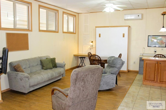 living room with ceiling fan, light hardwood / wood-style floors, and a wall mounted AC