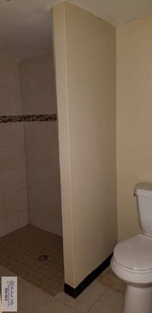 1287 Delpha Dr, Brownsville, TX 78521 - bathroom featuring toilet, a stall shower, and tile patterned flooring
