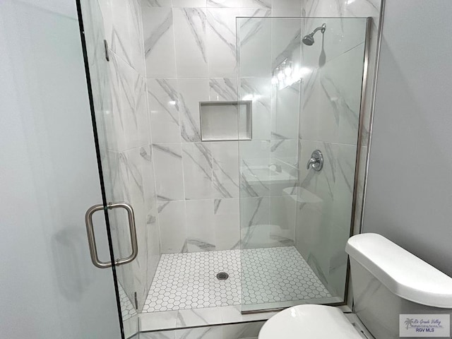 bathroom with a shower stall and toilet
