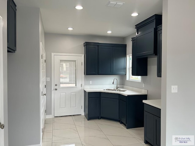 kitchen with visible vents, light countertops, recessed lighting, marble finish floor, and a sink