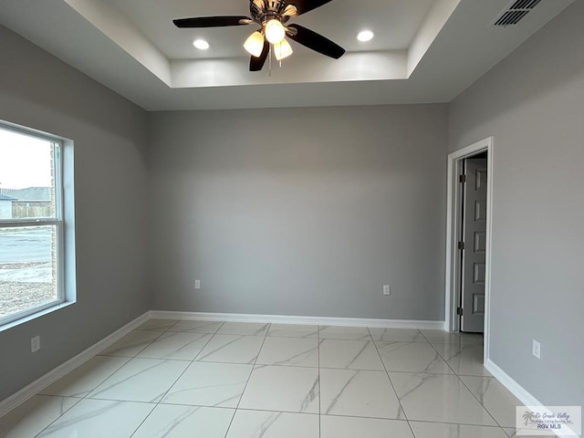 empty room with visible vents, baseboards, ceiling fan, recessed lighting, and a raised ceiling