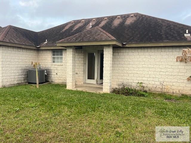 back of house with central AC and a yard