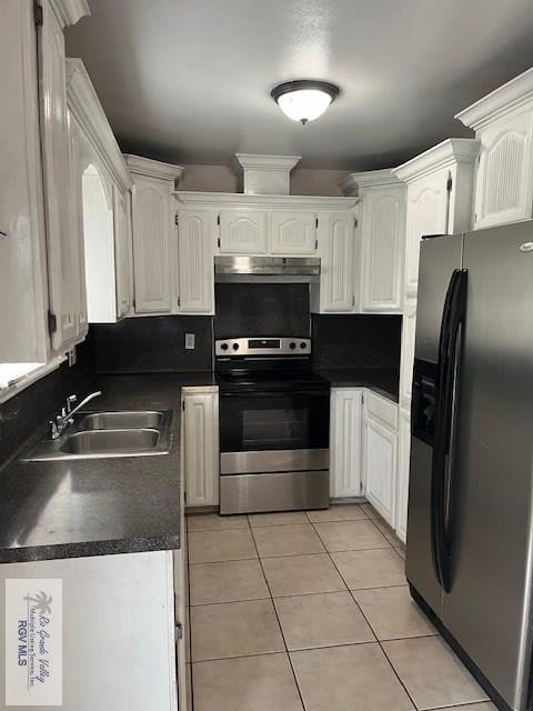 kitchen with light tile patterned flooring, appliances with stainless steel finishes, sink, and white cabinets