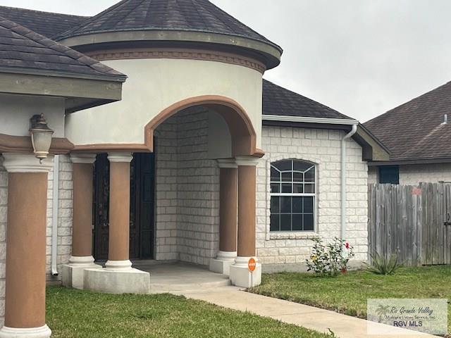 view of exterior entry with a yard