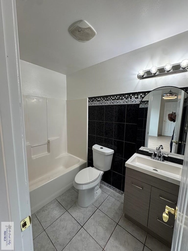 2408 Munich St, Brownsville, TX 78520 - bathroom with vanity, tile patterned flooring, toilet, tile walls, and shower / bathtub combination