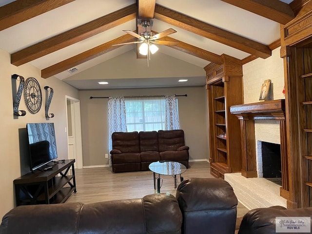 living area with a fireplace, visible vents, lofted ceiling with beams, wood finished floors, and baseboards