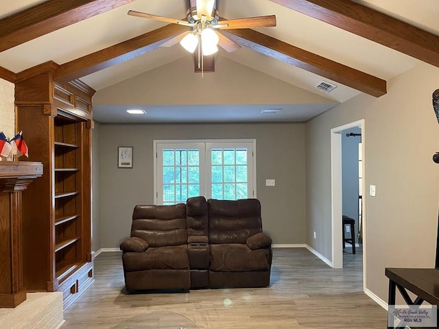 living room featuring lofted ceiling with beams, baseboards, and wood finished floors