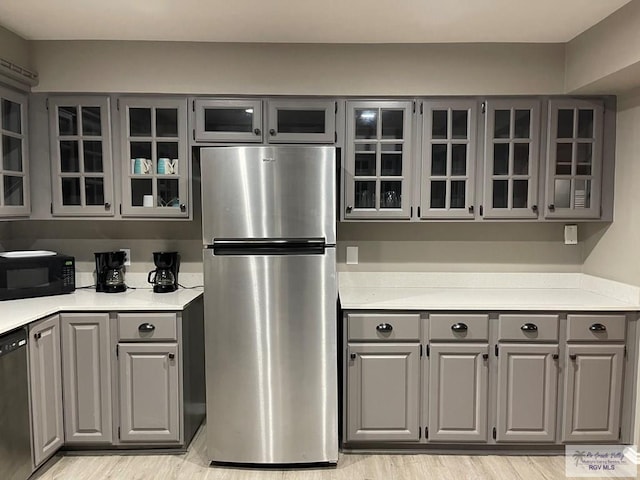 kitchen with glass insert cabinets, gray cabinetry, and black appliances