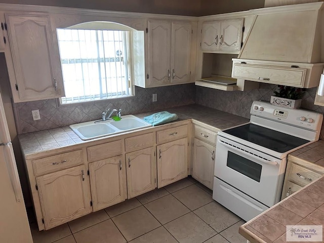 kitchen featuring decorative backsplash, white appliances, tile counters, and sink