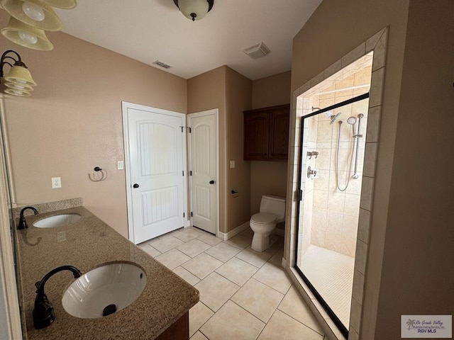 bathroom with tile patterned floors, vanity, an enclosed shower, and toilet