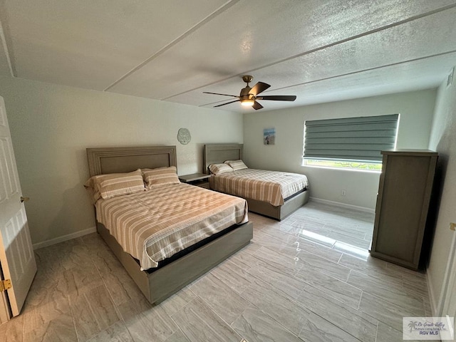 bedroom with a textured ceiling, light wood-type flooring, and ceiling fan