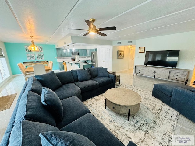 living room with ceiling fan and light wood-type flooring