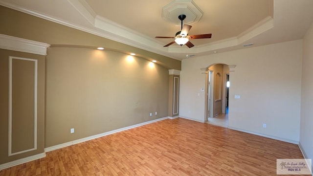 5805 Acacia, Harlingen, TX 78552 - unfurnished room featuring light wood-type flooring, ornate columns, arched walkways, a raised ceiling, and a ceiling fan