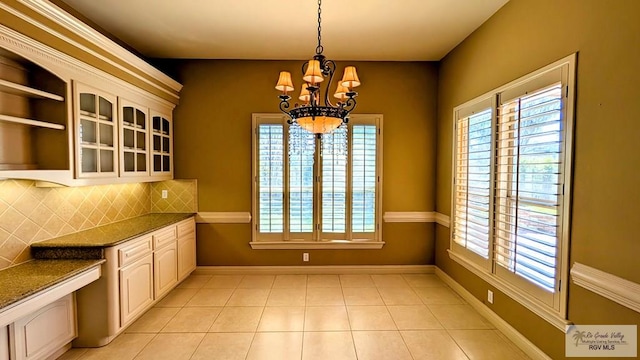 5805 Acacia, Harlingen, TX 78552 - unfurnished dining area featuring a notable chandelier, baseboards, and light tile patterned floors