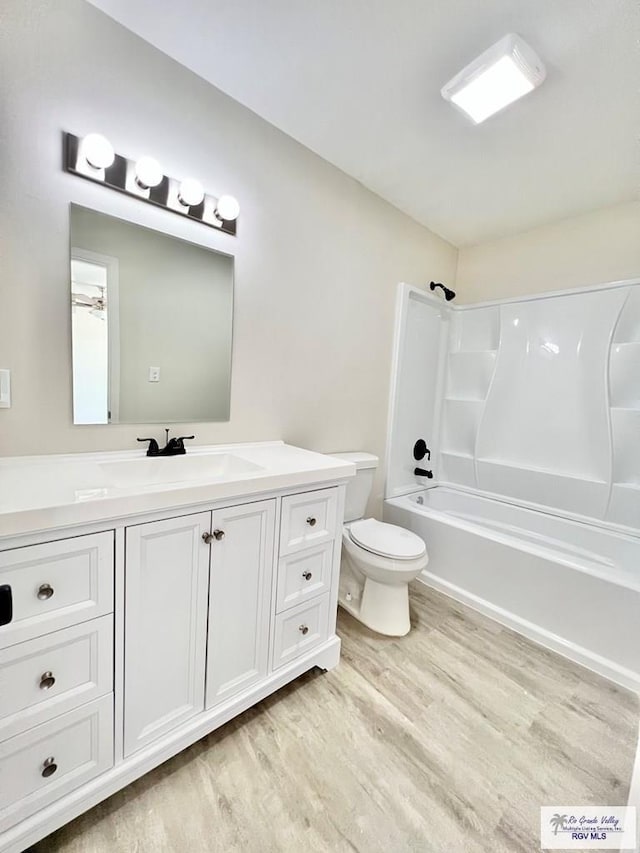 full bathroom featuring wood-type flooring, toilet, shower / bathing tub combination, and vanity