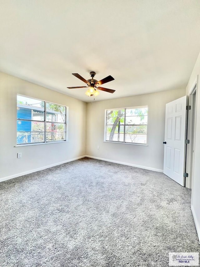 spare room with carpet floors, a wealth of natural light, and ceiling fan