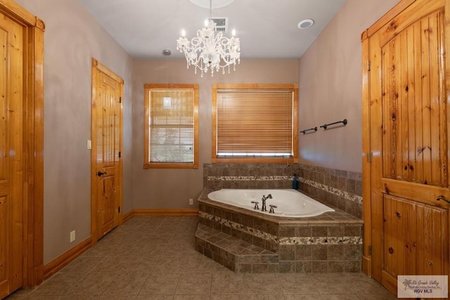 bathroom featuring tile patterned flooring, a relaxing tiled tub, and an inviting chandelier