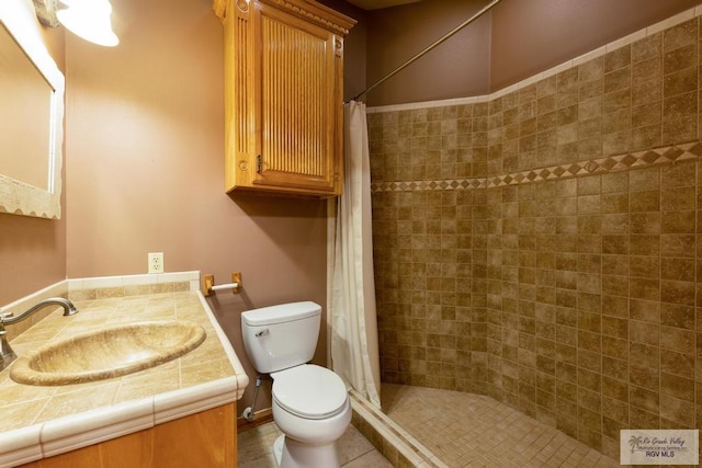 bathroom featuring walk in shower, tile patterned floors, vanity, and toilet