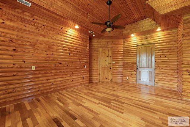 empty room featuring ceiling fan, log walls, a towering ceiling, light hardwood / wood-style floors, and wood ceiling