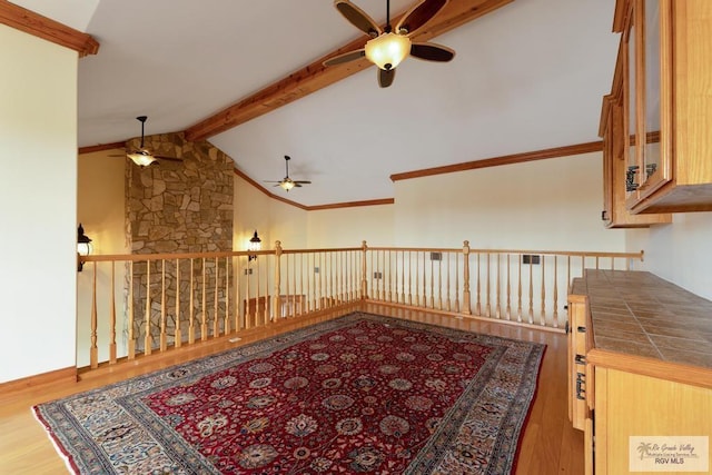 interior space with vaulted ceiling with beams, ceiling fan, and wood-type flooring