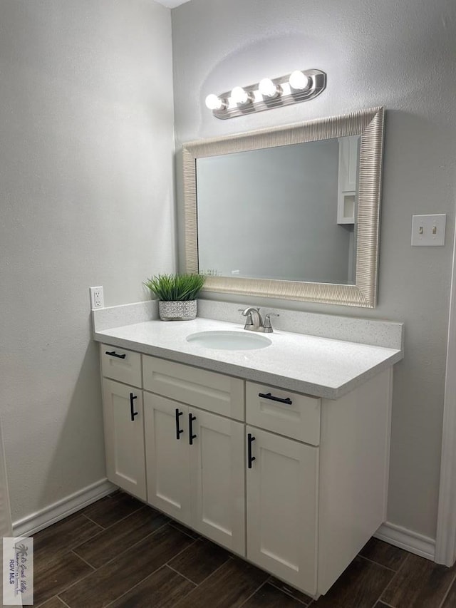 917 S Houston Dr, Harlingen, TX 78550 - bathroom with vanity, baseboards, and wood finish floors
