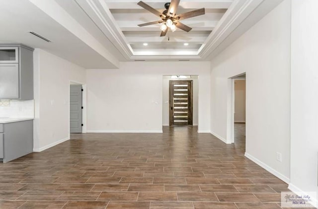 unfurnished living room with dark hardwood / wood-style flooring, a raised ceiling, and ceiling fan