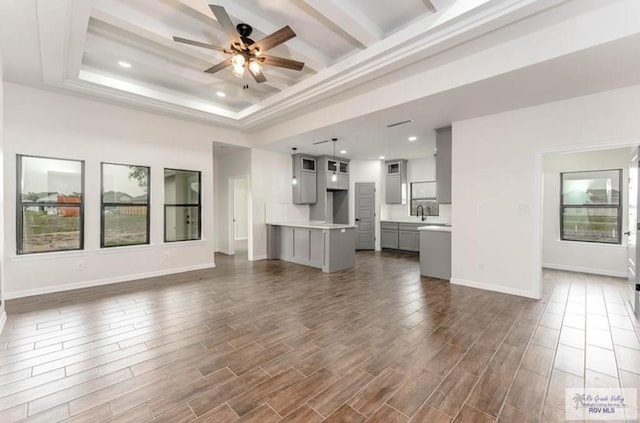 unfurnished living room featuring a wealth of natural light, dark hardwood / wood-style flooring, and ceiling fan