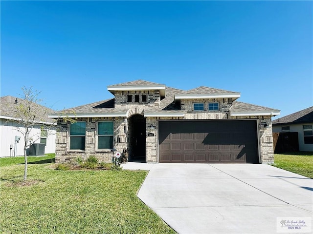 prairie-style home with central AC unit, a garage, and a front lawn