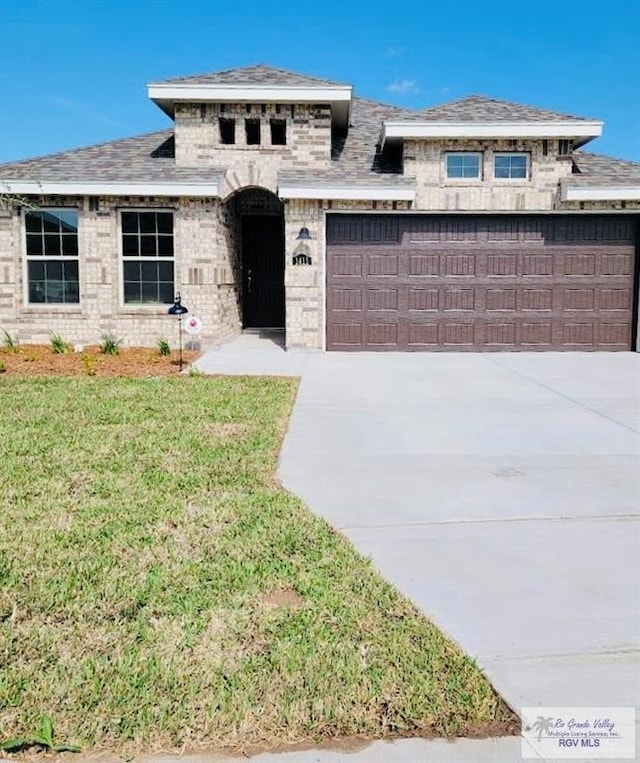 prairie-style home with a front lawn and a garage