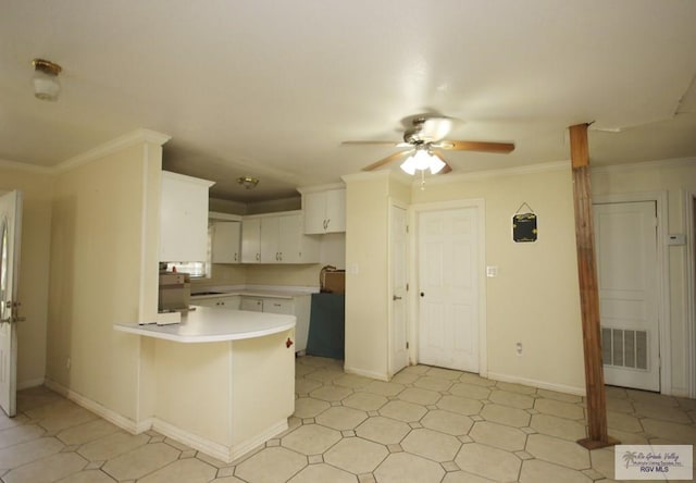825 E Vinson Ave, Harlingen, TX 78550 - kitchen featuring a peninsula, a ceiling fan, light countertops, white cabinetry, and crown molding