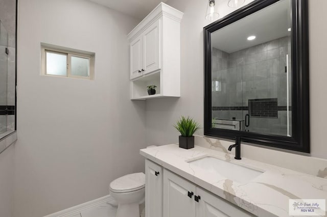 1606 Arden St, Mercedes, TX 78570 - bathroom with marble look tiles, toilet, vanity, a shower stall, and baseboards