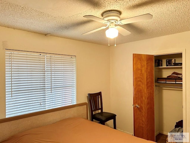 bedroom featuring ceiling fan, a textured ceiling, and a closet