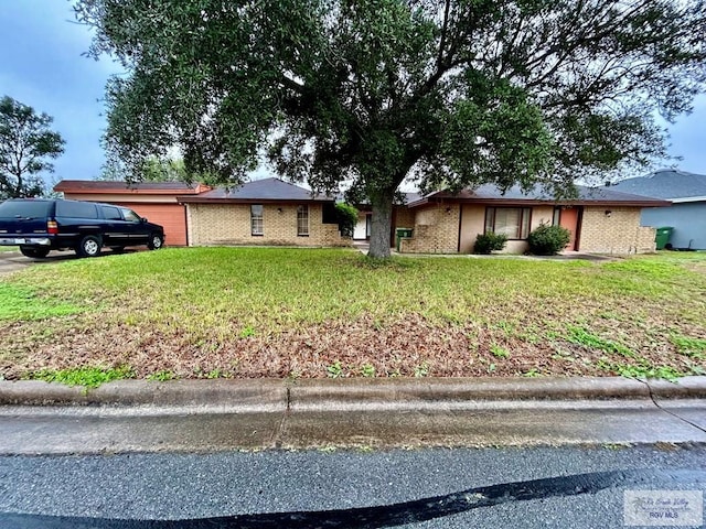 single story home featuring a front lawn and a garage