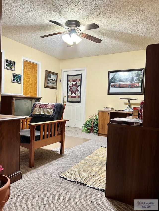 office with a textured ceiling, carpet floors, and ceiling fan