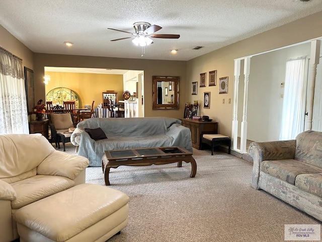 carpeted living room featuring ceiling fan and a textured ceiling