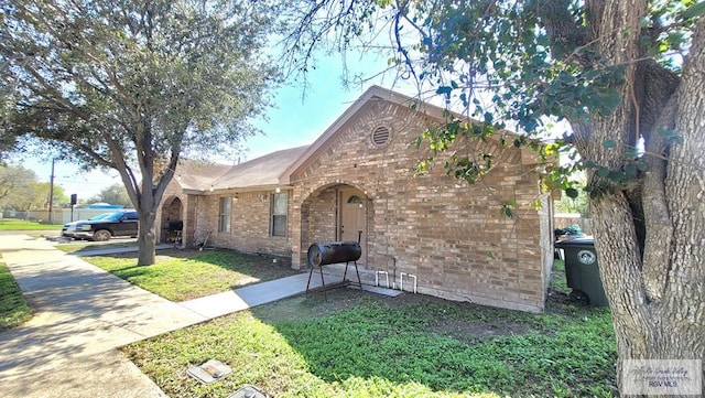 view of front of home featuring brick siding and a front yard