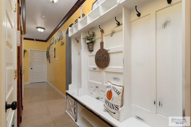 mudroom featuring light tile patterned flooring and crown molding