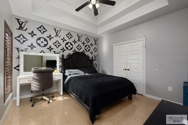 bedroom featuring a tray ceiling, ceiling fan, and tile patterned flooring