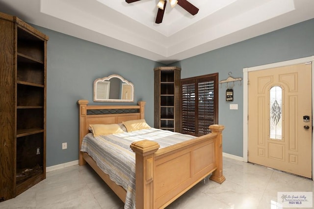 bedroom with ceiling fan and a tray ceiling