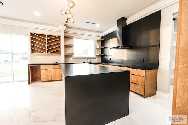 kitchen featuring sink, a kitchen island, wall chimney range hood, and ornamental molding