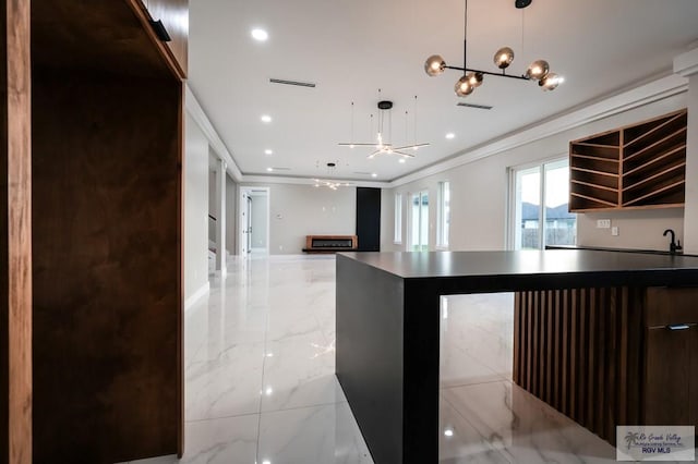 kitchen with a center island, decorative light fixtures, ceiling fan, and crown molding