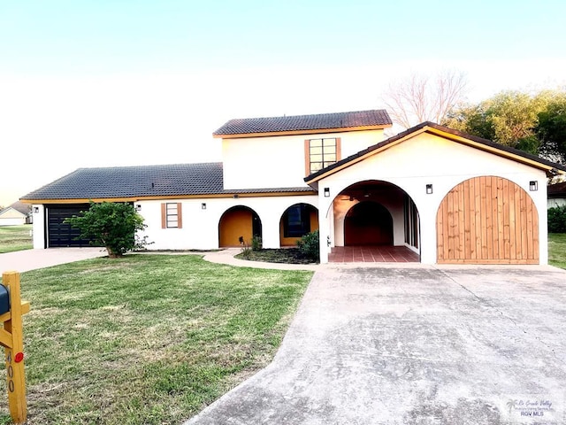 mediterranean / spanish house with a garage and a front yard